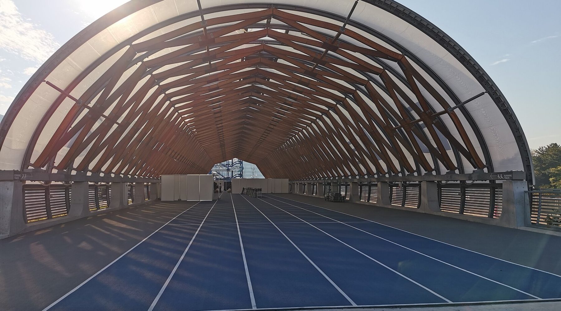 Modern covered running track with wooden truss roof