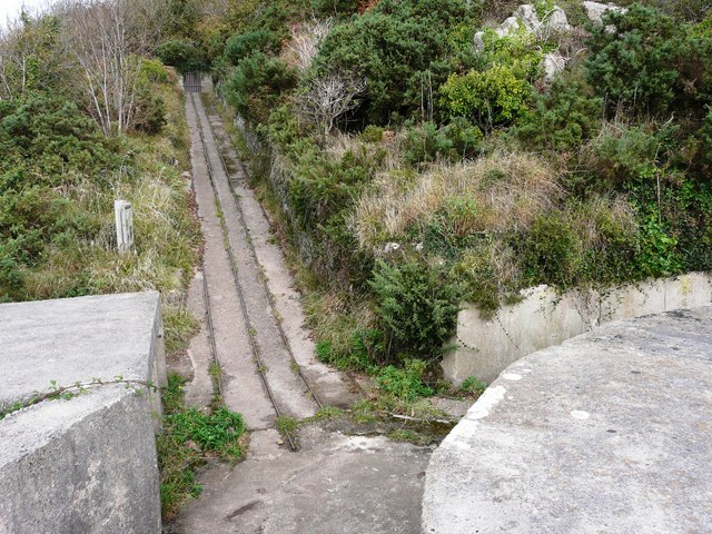 Overgrown concrete incline track at an old fortification